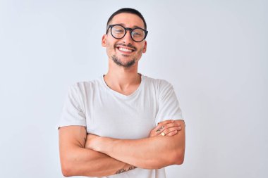 Gözlük takan genç yakışıklı ve izole edilmiş arka planda duran mutlu yüzlü kollarını kavuşturup kameraya bakan adam. Pozitif kişi.