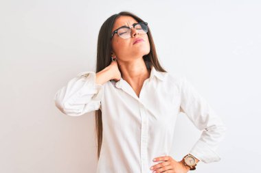 Gözlüklü genç, güzel bir iş kadını. İzole edilmiş beyaz arka planda duruyor. Boyun ağrısı çekiyor.