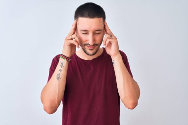 Tecrit edilmiş arka planda duran genç ve yakışıklı bir adam. Başında ağrı var çünkü stres var. Migren ağrısı..