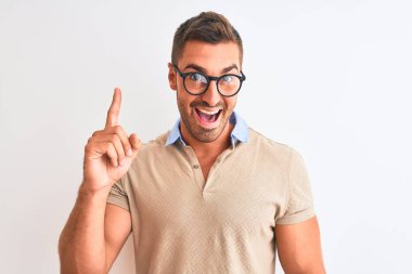 Başarılı fikirle izole arka plan işaret parmağı üzerinde gözlük takan yakışıklı delikanlı. Çıktıktan ve mutlu. Bir numara.