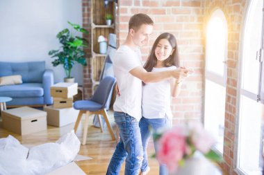 Karton kutular etrafında yeni evde dans genç güzel çift