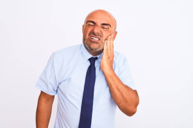 Orta yaşlı iş adamı, diş ağrısı ya da diş ağrısı yüzünden izole edilmiş beyaz arka planda duran kravat takıyor ve ağızlarına acı dolu bir ifadeyle dokunuyor. Dişçi konsepti.