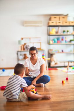 Anaokulunda traktör ve arabalarla oynayan güzel öğretmen ve çocuk.