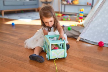 Anaokulunda oyuncak oyuncaklarıyla oynayan sevimli sarışın çocuk.