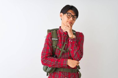 Sırt çantalı matara gözlüklü Çinli adam izole edilmiş beyaz arka planda kolları çapraz ve çenesi havada kameraya bakıp gülümsüyor. Olumlu düşünüyorum..