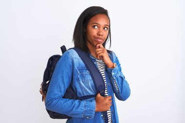 Sırt çantası takan Afrikalı Amerikalı genç bir bayan izole edilmiş arka planda ciddi bir yüz soru düşünüyor, çok karışık bir fikir.