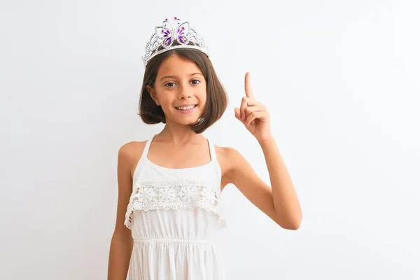 美しい子供の女の子は王女の王冠を着て成功したアイデアで指を指して隔離された白い背景の上に立っている 興奮し 第一番 — ストック写真