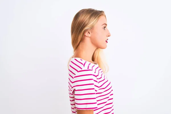 年轻美丽的女人穿着粉色条纹T恤 站在孤零零的白色背景上 望着旁边 带着自信的微笑 放松地摆出自然的姿态 — 图库照片