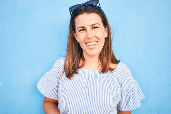 Hermosa Chica Apoyada Pared Azul Joven Mujer Amigable Sonriendo Feliz — Foto de Stock