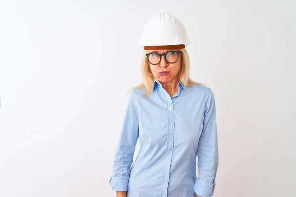 中年建筑师女人戴着眼镜和头盔 戴在孤立的白色背景上 满脸滑稽地鼓起双颊 满嘴通气 满嘴疯狂的表情 — 图库照片