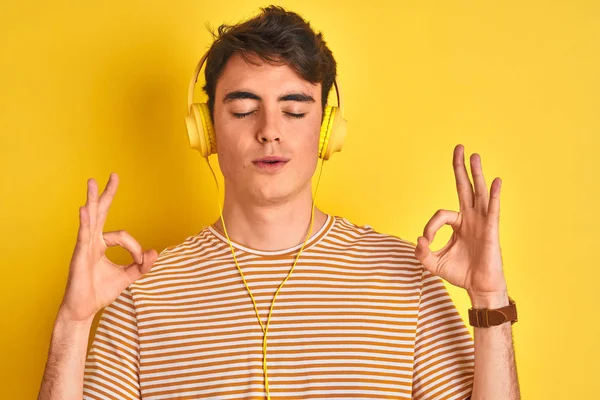 Adolescente Niño Usando Auriculares Sobre Fondo Amarillo Aislado Relajarse Sonreír —  Fotos de Stock