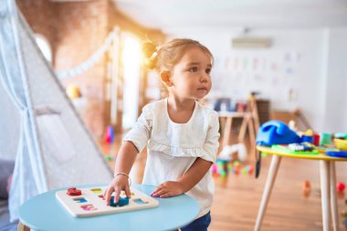 Anaokulunda matematik oyunu oynayan genç ve güzel bir çocuk.