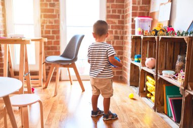Anaokulunda renkli küçük toplarla oynayan güzel bir çocuk.