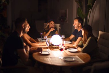 Güzel bir aile akşam yemeğinde terasta konuşuyor ve gülümsüyor