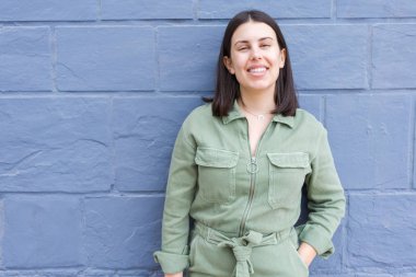 Genç güzellik kadını şehrin sokakta mutlu mutlu duvara yaslanmış gülümseyen