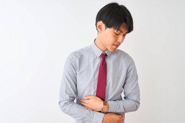 Çin iş adamı zarif bir kravat takıyor, midesi üstünde beyaz bir arka plan üzerinde duruyor çünkü hazımsızlık, acı verici bir hastalık kendini iyi hissetmiyor. Ache kavramı.