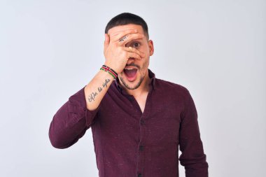 Genç yakışıklı iş adamı izole edilmiş arka planda duruyor. Şoka giriyor. Yüzü ve gözleri kapanıyor, utangaç ifadesiyle parmaklarından bakıyor..