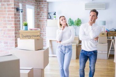 Genç ve güzel bir çift, yeni evlerinde karton kutuların etrafında, elleri çenelerinde soru sorarken, düşünceli bir ifade takınıyorlar. Düşünceli bir yüzle gülümsüyor. Şüphe kavramı.