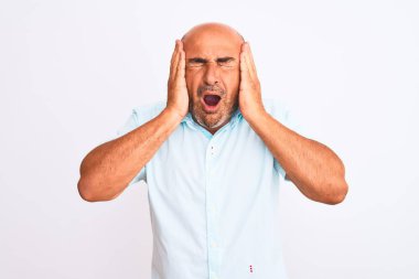 Orta yaşlı yakışıklı bir adam, izole edilmiş beyaz arka planda dikilip stres yüzünden kafa üstü başı ağrıyan sıradan bir gömlek giyiyor. Migren ağrısı..