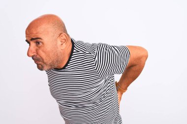 Orta yaşlı yakışıklı bir adam, izole edilmiş beyaz bir arka plan üzerine çizgili donanma tişörtü giyiyor sırt ağrısı çekiyor, elle dokunuyor, kas ağrısı çekiyor.