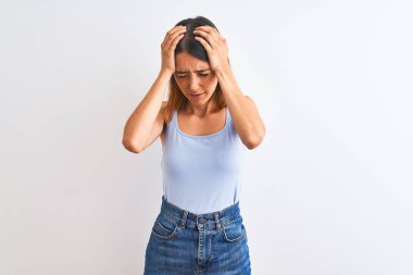 Beautiful redhead woman standing over isolated background suffering from headache desperate and stressed because pain and migraine. Hands on head.