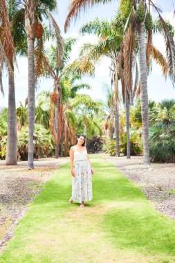 Güneşli bir yaz gününde yeşil parkta mutlu ve neşeli gülümseyen güzel bir kadın.