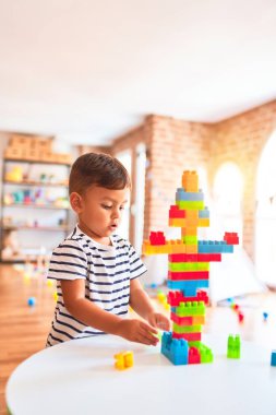 Güzel çocuk anaokulunda inşaat bloklarıyla oynuyor.