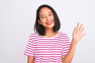 Young chinese woman wearing striped t-shirt standing over isolated white background showing and pointing up with fingers number five while smiling confident and happy.