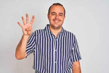 Young man wearing blue striped shirt standing over isolated white background showing and pointing up with fingers number four while smiling confident and happy.