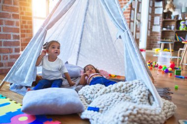 Sevimli bebekler, Tip 'in içinde, anaokulunda sırıtarak battaniyenin üzerine uzanırlar.