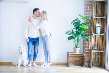 Yeni evinde köpek öpen genç ve güzel bir çift.