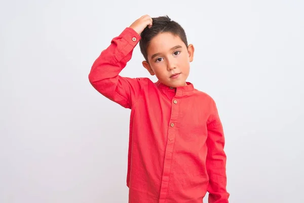 孤立した白い背景の上に立つエレガントな赤いシャツを着て美しい少年は混乱し 質問について疑問に思います 疑いもなく 頭の上で手で考えて 包括的概念 — ストック写真