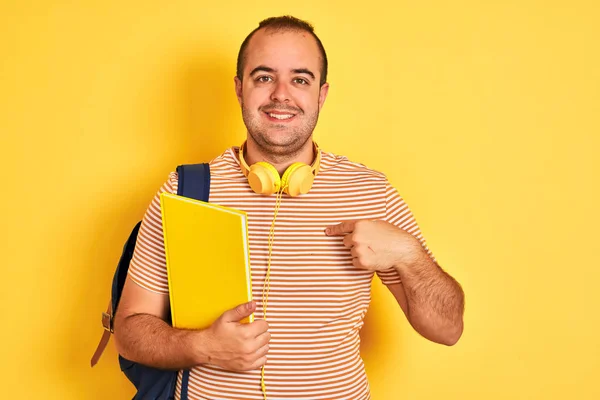 Student Man Wearing Backpack Headphones Holding Notebook Isolated Yellow Background — 스톡 사진