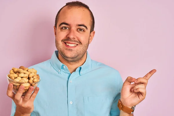 Jongeman Houden Kom Met Pinda Staan Geïsoleerde Roze Achtergrond Zeer — Stockfoto