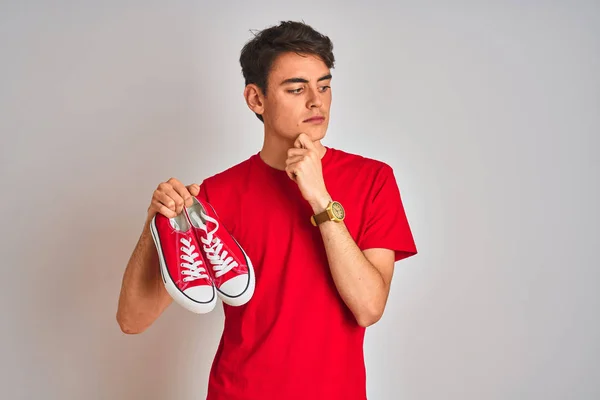Teenager Boy Holding Fashion Casual Sneakers Red Isolated Background Serious — Stok fotoğraf