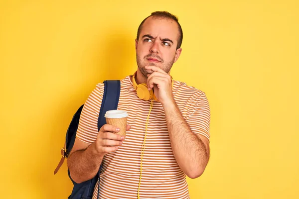 Student Noszący Słuchawki Plecaka Pijący Kawę Odizolowanym Żółtym Tle Poważna — Zdjęcie stockowe
