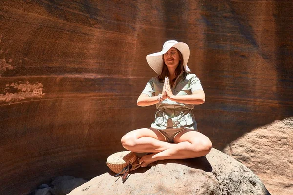 Young beauitufl hiker woman trekking natural orange mountain doing yoga pose on summer holidays