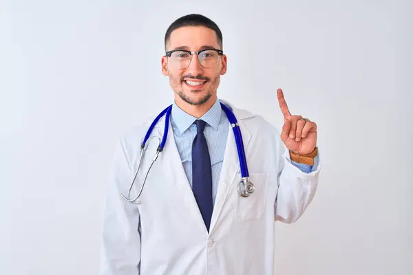 年轻的医生 带着听诊器 站在孤立的背景上 带着第一指尖 面带微笑 自信而快乐 — 图库照片