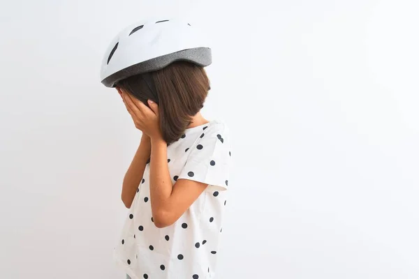 漂亮的小女孩戴着安全自行车头盔 站在孤独的白色背景上 脸上挂着悲伤的表情 一边哭一边用手捂住脸 抑郁症的概念 — 图库照片