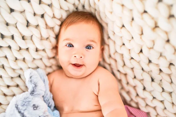 可爱的婴儿躺在沙发上的毛毯上 开心地在家里笑着 初生时面带微笑放松 泰迪熊舒适地休息 — 图库照片