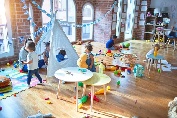 Mooie Leraar Groep Peuters Spelen Rond Veel Speelgoed Kleuterschool — Stockfoto