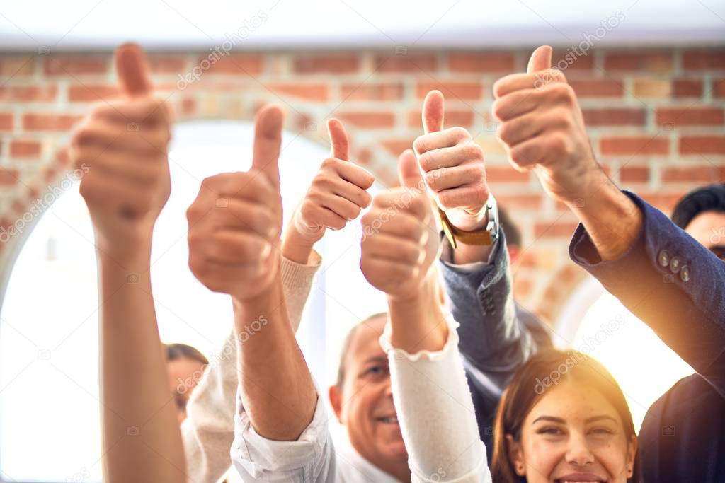 Group of business workers smiling happy. Standing with thumbs up at the office