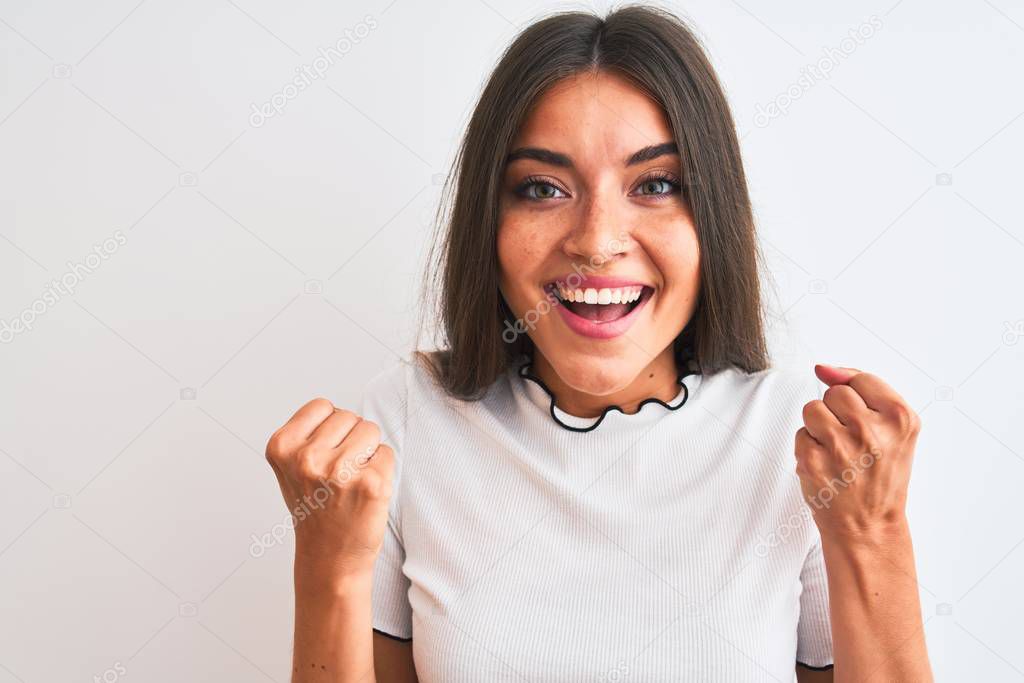 Young beautiful woman wearing casual t-shirt standing over isolated white background screaming proud and celebrating victory and success very excited, cheering emotion