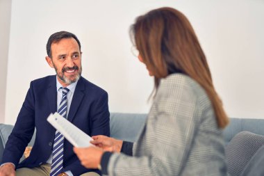 Mutlu ve kendinden emin gülümseyen iki orta yaşlı iş adamı. Ofiste evrakları tutarken gülümseme ile birlikte çalışmak.