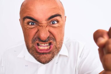 Soyutlanmış beyaz arka planda duran zarif tişörtlü yakışıklı bir adam öfkeyle bağırıyor, çıldırıyor ve öfkeyle bağırıyor.