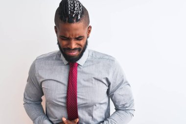 African american businessman with braids wearing tie standing over isolated white background with hand on stomach because nausea, painful disease feeling unwell. Ache concept.