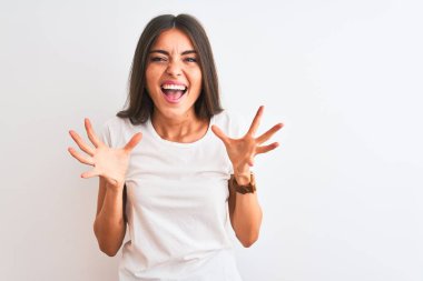 Genç güzel kadın rahat t-shirt giyen izole beyaz arka plan üzerinde duran deli kutluyor ve kollarını kaldırdı ve açık gözleri heyecan çığlık ile başarı için hayran. Kazanan kavramı