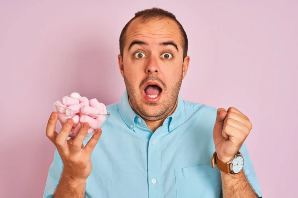 Young Man Holding Bowl Marshmallows Standing Isolated Pink Background Screaming — Stok fotoğraf