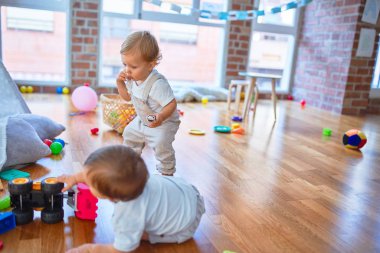 Anaokulunda bir sürü oyuncakla oynayan güzel çocuklar.
