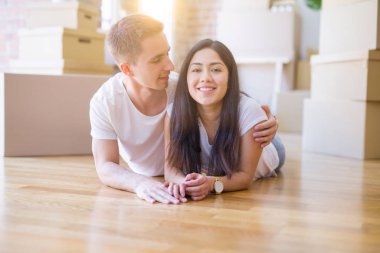 Genç güzel çift karton kutular etrafında yeni evde yatarken